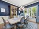 Stylish dining room with a large window, blue walls, and a elegant chandelier at 6824 Wood Forest Dr, Cary, NC 27519