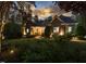 Stunning home exterior at dusk, featuring stone accents, manicured landscaping, and a welcoming front entrance at 6824 Wood Forest Dr, Cary, NC 27519
