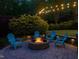 Cozy backyard fire pit with Adirondack chairs and ambient string lights for outdoor entertaining at 6824 Wood Forest Dr, Cary, NC 27519