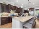 Gourmet kitchen with stainless steel appliances, a spacious island, and elegant dark wood cabinetry at 6824 Wood Forest Dr, Cary, NC 27519