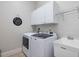 Laundry room featuring a modern washer and dryer, white cabinetry, and a utility sink at 6824 Wood Forest Dr, Cary, NC 27519