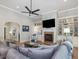 Inviting living room featuring a fireplace, custom built-ins and comfortable sectional seating at 6824 Wood Forest Dr, Cary, NC 27519