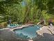 Backyard with a custom pool, waterslide, and lush greenery, creating a private oasis at 6824 Wood Forest Dr, Cary, NC 27519
