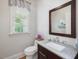 Bright powder room with modern vanity, granite countertop, and decorative mirror at 6824 Wood Forest Dr, Cary, NC 27519