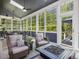 Relaxing screened porch offers cozy seating, a fire pit table, and wooded views at 6824 Wood Forest Dr, Cary, NC 27519
