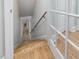 Staircase with hardwood steps, white risers, and white trim next to white framed window at 6824 Wood Forest Dr, Cary, NC 27519