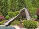 Backyard waterslide surrounded by lush landscaping, adding a touch of fun to the outdoor space at 6824 Wood Forest Dr, Cary, NC 27519