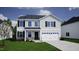 Exterior elevation of a two-story home with stone accents, a two-car garage, and a well-manicured lawn at 75 Cordoba Dr, Franklinton, NC 27525