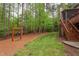 Backyard with a swing set, stairs to a deck, and lush, green lawn at 7633 Summer Pines Way, Wake Forest, NC 27587