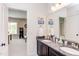 Bathroom featuring double sink vanity, large mirror and doorway to a room with an arcade game at 7633 Summer Pines Way, Wake Forest, NC 27587