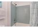 Bathtub shower with light blue subway tile surround and brushed silver hardware at 7633 Summer Pines Way, Wake Forest, NC 27587