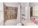 Bathroom featuring decorative tile around the tub with a large white storage cabinet and marble countertop at 7633 Summer Pines Way, Wake Forest, NC 27587