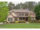 Charming two-story home with stone and shingle facade, complemented by lush landscaping and a cozy front porch at 7633 Summer Pines Way, Wake Forest, NC 27587