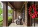 Inviting front porch with comfortable seating and a stone facade, perfect for relaxing outdoors at 7633 Summer Pines Way, Wake Forest, NC 27587