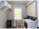 Functional laundry room with washer, dryer, storage shelves, and laundry sorter at 7633 Summer Pines Way, Wake Forest, NC 27587