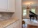 View of a grand piano and decorative chandelier in the living room at 7633 Summer Pines Way, Wake Forest, NC 27587