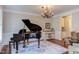 Spacious living room featuring a grand piano, chandelier, and elegant decor at 7633 Summer Pines Way, Wake Forest, NC 27587