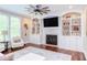 Cozy living room featuring a fireplace, custom built-ins, and a ceiling fan at 7633 Summer Pines Way, Wake Forest, NC 27587