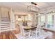 Open-concept dining and kitchen area with hardwood floors and access to a staircase and patio at 7633 Summer Pines Way, Wake Forest, NC 27587