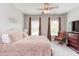 Cozy main bedroom with a comfortable bed, ceiling fan, carpet flooring and natural light from two windows at 7633 Summer Pines Way, Wake Forest, NC 27587