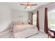 Bedroom featuring neutral walls, carpet flooring, ceiling fan, and natural light from windows with brown drapes at 7633 Summer Pines Way, Wake Forest, NC 27587