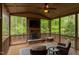 Screened porch featuring a stone fireplace, ceiling fan, and outdoor furniture at 7633 Summer Pines Way, Wake Forest, NC 27587