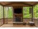 Screened porch featuring a stone fireplace, ceiling fan, and outdoor furniture at 7633 Summer Pines Way, Wake Forest, NC 27587