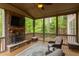 Cozy screened porch featuring a stone fireplace, ceiling fan and comfortable seating with wooded views at 7633 Summer Pines Way, Wake Forest, NC 27587