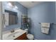 Bathroom with blue walls, white sink, and storage shelf at 7653 Summerglen Dr, Raleigh, NC 27615