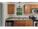 Well-lit kitchen with stainless steel appliances, granite counters, and wooden cabinetry at 7653 Summerglen Dr, Raleigh, NC 27615