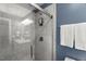 Bathroom shower with glass door, chrome hardware, white subway tile, and painted blue walls at 7653 Summerglen Dr, Raleigh, NC 27615
