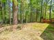 View of the wooded backyard with a small wood deck and bench seating at 7716 Bluff Top Court Ct, Raleigh, NC 27615
