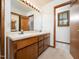 Well-lit bathroom with double sinks, wood cabinets, and a view into the toilet and shower room at 7716 Bluff Top Court Ct, Raleigh, NC 27615