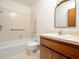 Well-lit bathroom with tub-shower combo, single sink vanity and decorative mirror at 7716 Bluff Top Court Ct, Raleigh, NC 27615