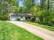 Charming single-story home with a long driveway, attached garage, and lush green lawn at 7716 Bluff Top Court Ct, Raleigh, NC 27615