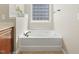 A view of the soaking tub in the bathroom with tile windows, perfect for relaxation at 7728 Cape Charles Dr, Raleigh, NC 27617