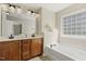 Bathroom boasting a double vanity, a large mirror, and a soaking tub with a tile window at 7728 Cape Charles Dr, Raleigh, NC 27617