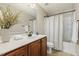 Bathroom with a single vanity featuring a white countertop, shower with curtain, and a decorative vase at 7728 Cape Charles Dr, Raleigh, NC 27617
