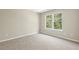 Spacious bedroom with two windows offering natural light and a view of lush greenery outside at 7728 Cape Charles Dr, Raleigh, NC 27617