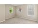 Bedroom filled with natural light from two windows, featuring neutral walls and plush carpeting at 7728 Cape Charles Dr, Raleigh, NC 27617