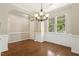 Dining room boasting hardwood floors, large windows, wainscoting, and stylish chandelier at 7728 Cape Charles Dr, Raleigh, NC 27617