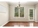 Bright dining area with hardwood floors, a view of the backyard, and a charming light fixture at 7728 Cape Charles Dr, Raleigh, NC 27617