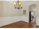 Dining room featuring hardwood floors, decorative wainscoting, and an elegant chandelier at 7728 Cape Charles Dr, Raleigh, NC 27617
