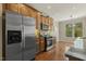 Bright kitchen featuring stainless steel appliances, granite countertops, and warm wood cabinets and floors at 7728 Cape Charles Dr, Raleigh, NC 27617