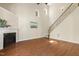 Open living room with high ceilings, hardwood floors, fireplace, and staircase to the second level at 7728 Cape Charles Dr, Raleigh, NC 27617