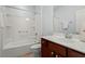 Bathroom features a white tub, shower and a vanity with cherry wood cabinets at 792 Eldridge Loop, Cary, NC 27519