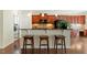 Modern kitchen with granite counters, cherry cabinets, and breakfast bar seating at 792 Eldridge Loop, Cary, NC 27519