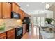 Kitchen featuring stainless steel appliances, granite countertops, and wood cabinetry at 792 Eldridge Loop, Cary, NC 27519