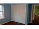 Bright bedroom featuring blue walls, wood floors, a window, and a closet with folding doors at 82 Whisper Ln, Pittsboro, NC 27312