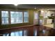 Bright living room with hardwood floors, large windows, and adjacent kitchen at 82 Whisper Ln, Pittsboro, NC 27312